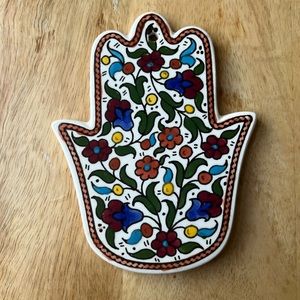 Ceramic hand / hamsa with painted flowers can placed on wall or left on table.